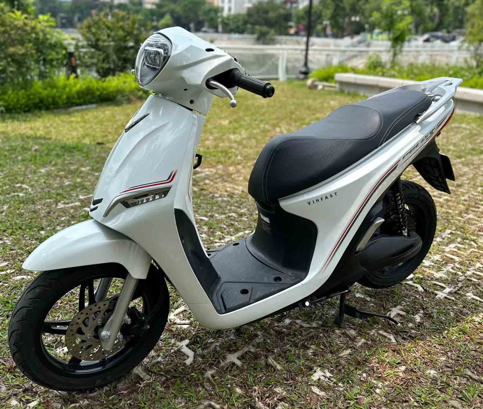 Một kỹ thuật viên đang kiểm tra hệ thống động cơ của một chiếc xe điện VinFast cũ