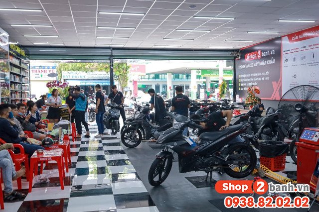 Một thợ cơ khí đang kiểm tra và sửa chữa động cơ xe máy trong môi trường chuyên nghiệp