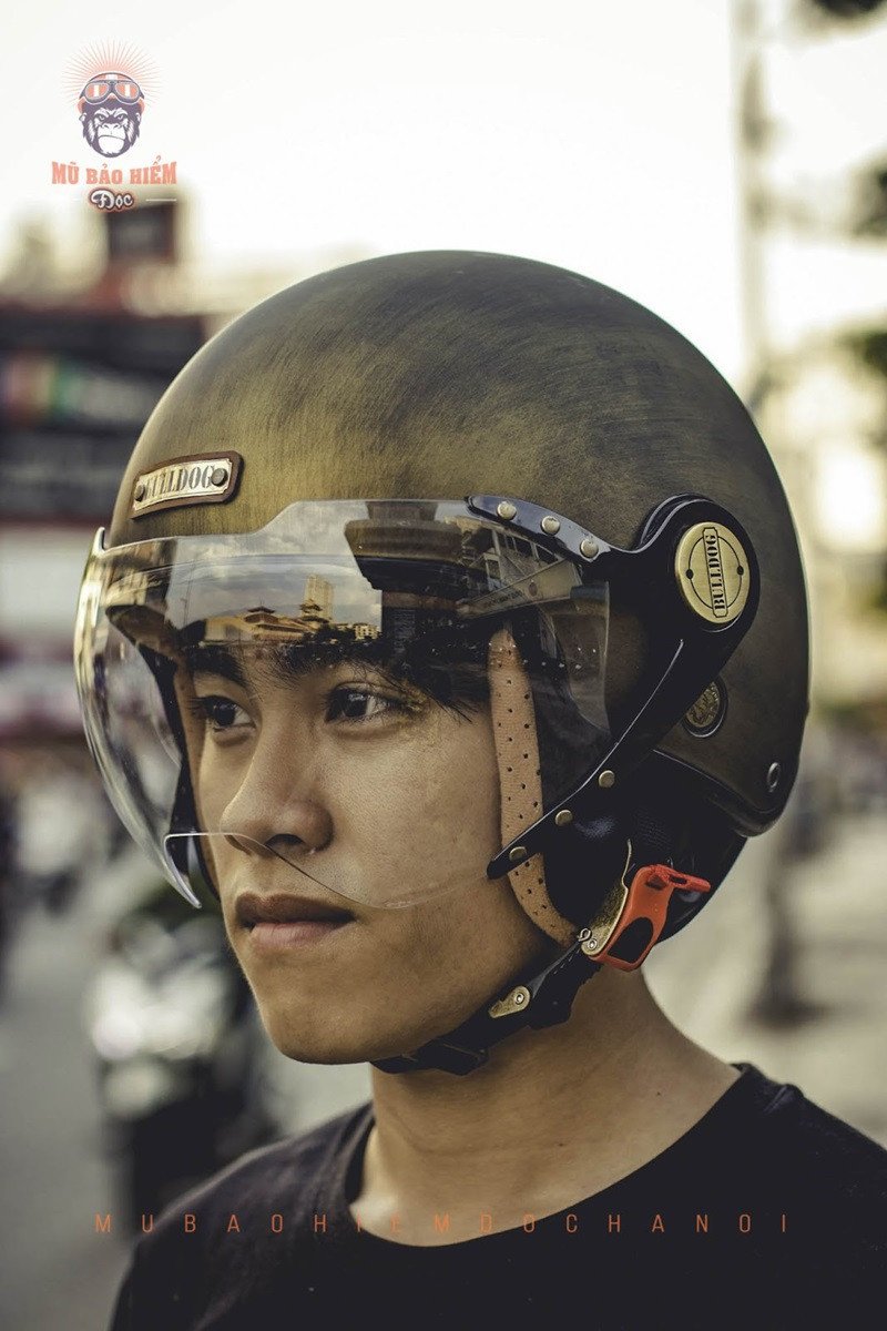 Người lái xe đội mũ bảo hiểm 3/4 màu trắng, nhìn về phía trước với tầm nhìn thoáng đãng.