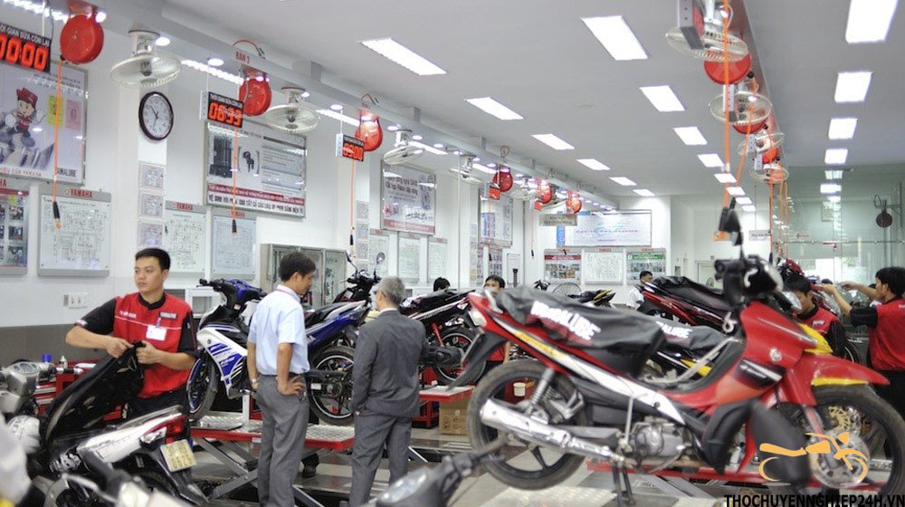 Nhân viên cứu hộ đang vá lốp xe máy Yamaha ngay trên đường