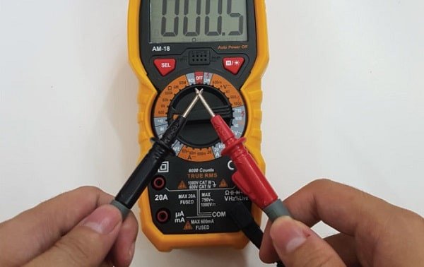 Thao tác chạm đầu dò đồng hồ vạn năng vào các chân cầu chì