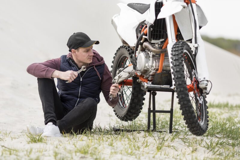 Thợ sửa chữa đang dùng dùi vá lốp xe máy không săm