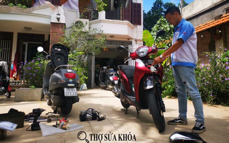 Thợ sửa xe đang kiểm tra chi tiết động cơ xe máy