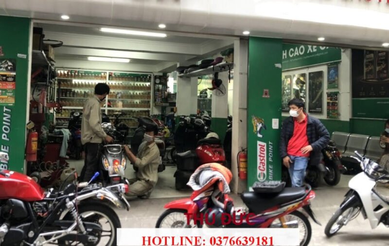 Thợ sửa xe máy đang kiểm tra động cơ xe tay ga