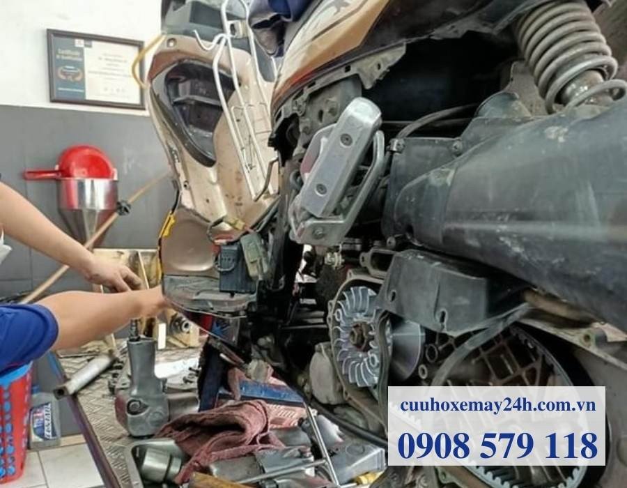 Thợ sửa xe máy Suzuki đang làm việc với dụng cụ chuyên dụng