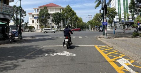 Xe máy chuyển hướng phải tại ngã tư có biển báo phụ cho phép rẽ phải khi đèn đỏ