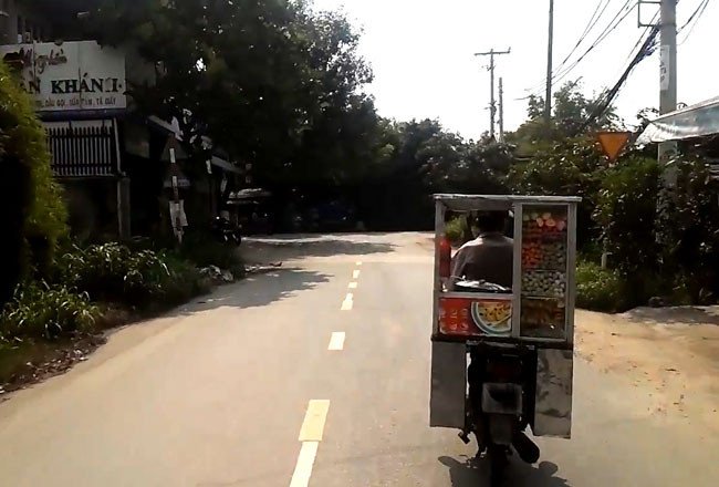 Xe máy đang di chuyển cùng tủ bán hàng