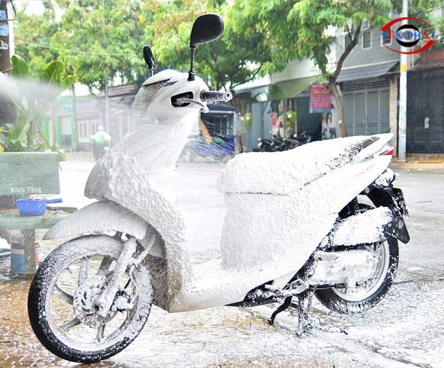 Xe máy đang được xịt rửa bằng máy áp lực cao tại một cửa hàng dịch vụ